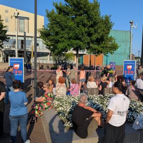 Demonstranten inmiddels op het plein; muziek, getrommel en een banner/spandoek