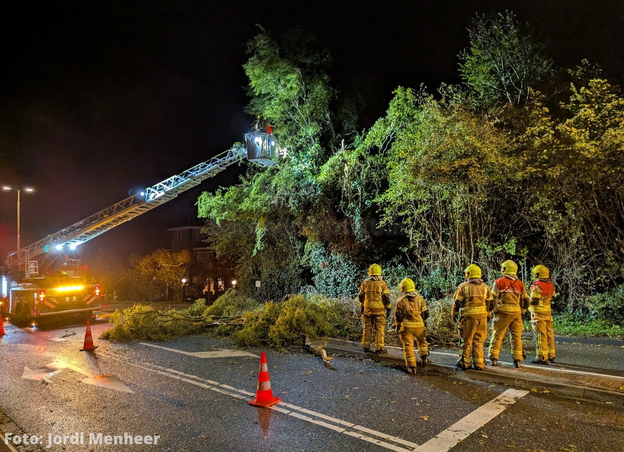 Foto: Takken van geknakte boom hangen over de 3e Barendrechtseweg, brandweer haalt de boom/takken we