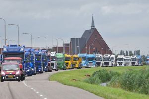 Truckrun met dolblije deelnemers rijd toeterend door Barendrecht