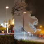 Vlammen slaan uit kledingcontainer aan de Vrijenburgweg