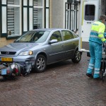 Scooter komt ten val tegen bumper van auto aan de Dorpsstraat in Barendrecht